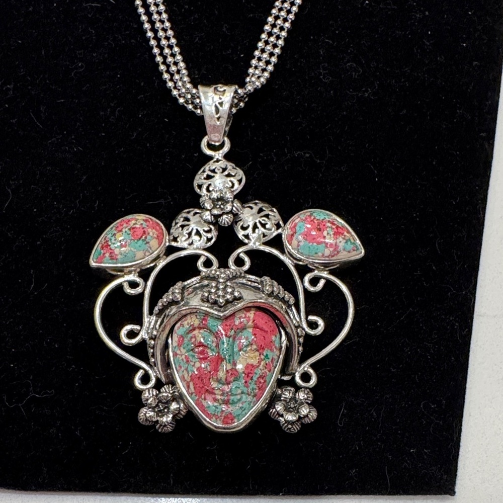 Carved gemstone face set within a decorative silver frame Pendant Necklace